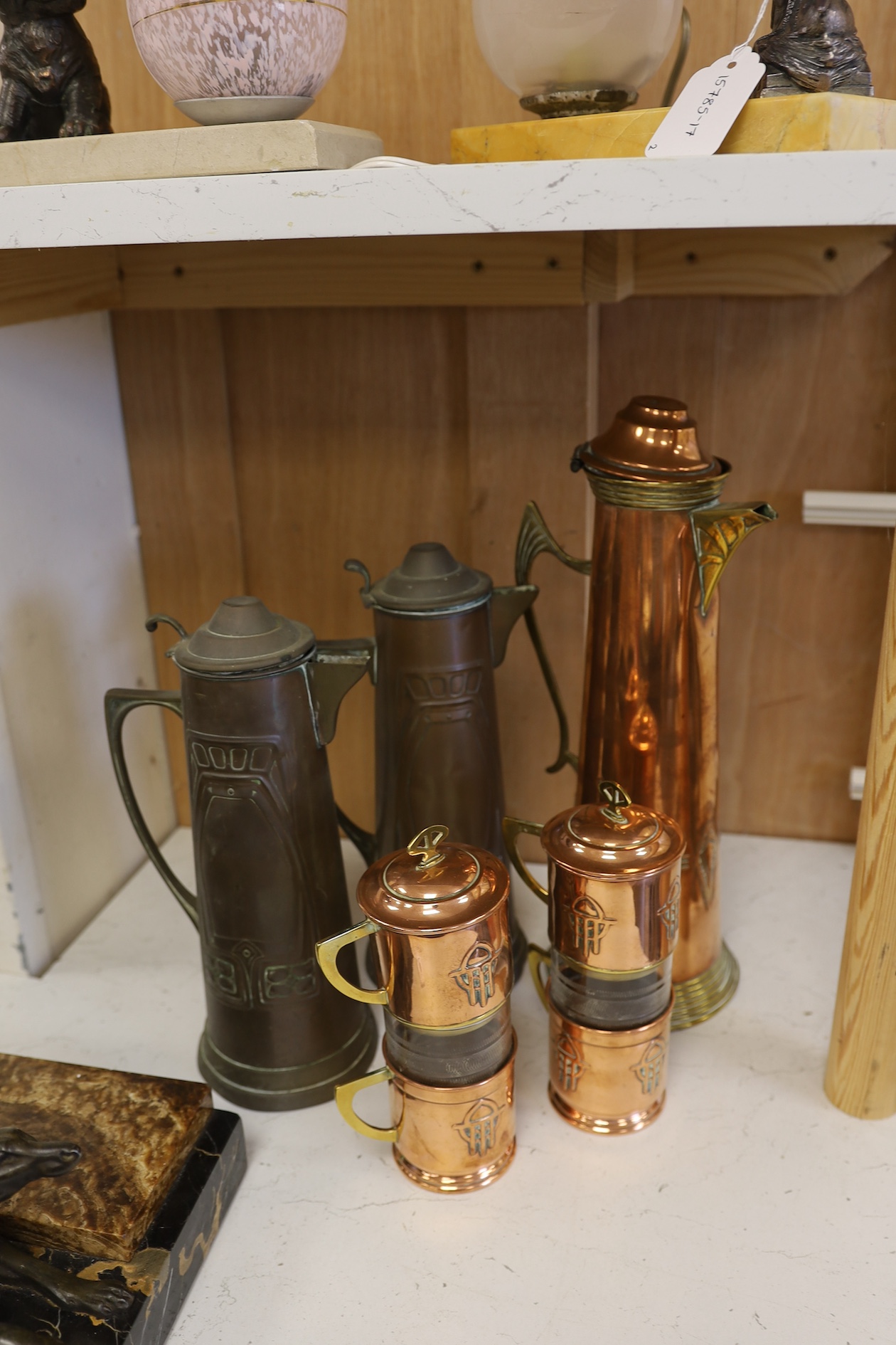 Three Art Nouveau mixed copper and brass coffee pots and two individual copper filter coffee glasses, tallest 36cm high (5). Condition - two pots need cleaning, but good condition for age